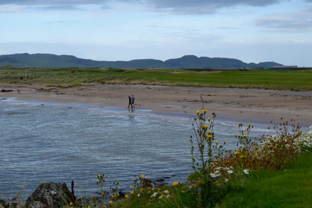 Evening walkers on the beach between the first tee and fairway at Machrihanish Golf Club.