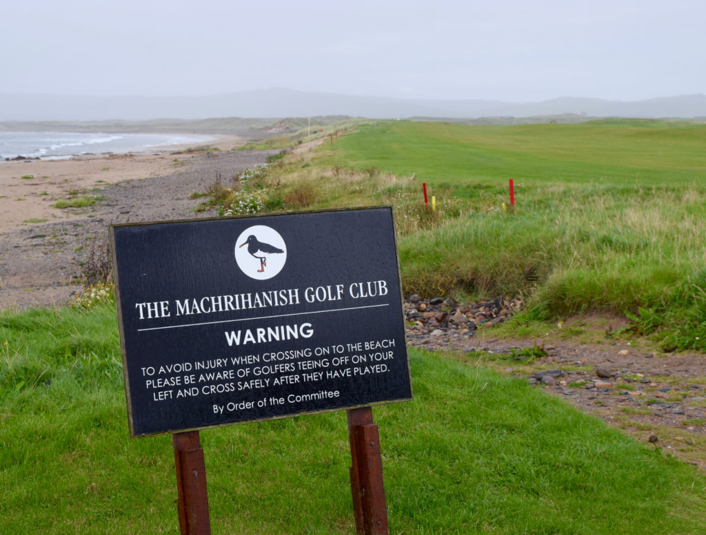 Walkers on the beach below the first tee at Machrihanish Golf Club are warned about the perils of errant shots.