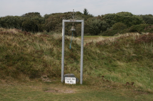 Golfers ring a bell to let the following group know it's safe to hit their blind tee shot on the 14th hole at Porthmadog Golf Club in North Wales.
