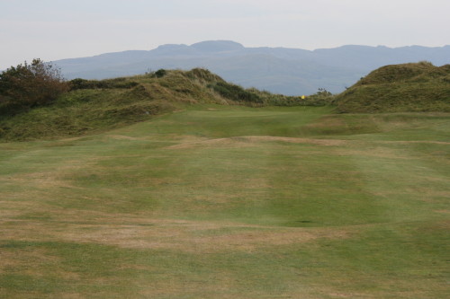 The green at the par 4 15th hole at Porthmadog Golf Club is tucked between two dunes.