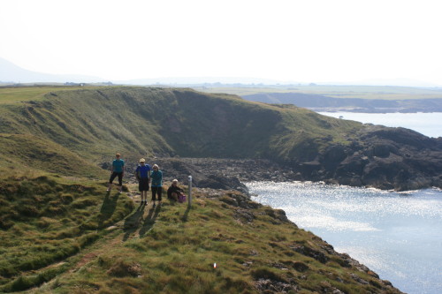 Hikers watch golfers tee off the No. 14 hole at Nefyn & District Golf Club, North Wales.